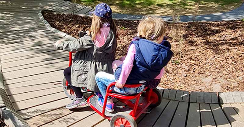 2 Kinderfahren auf einem Dreirad